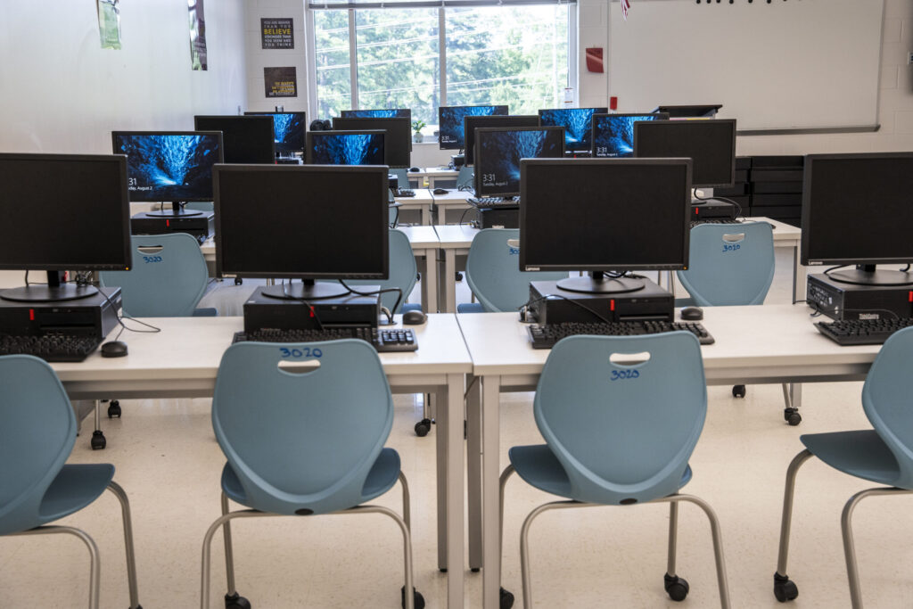 Student computers on desks in a classroom